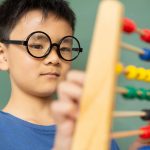 boy-learning-math-with-abacus-in-a-classroom-at-DE9N3LX-min.jpg